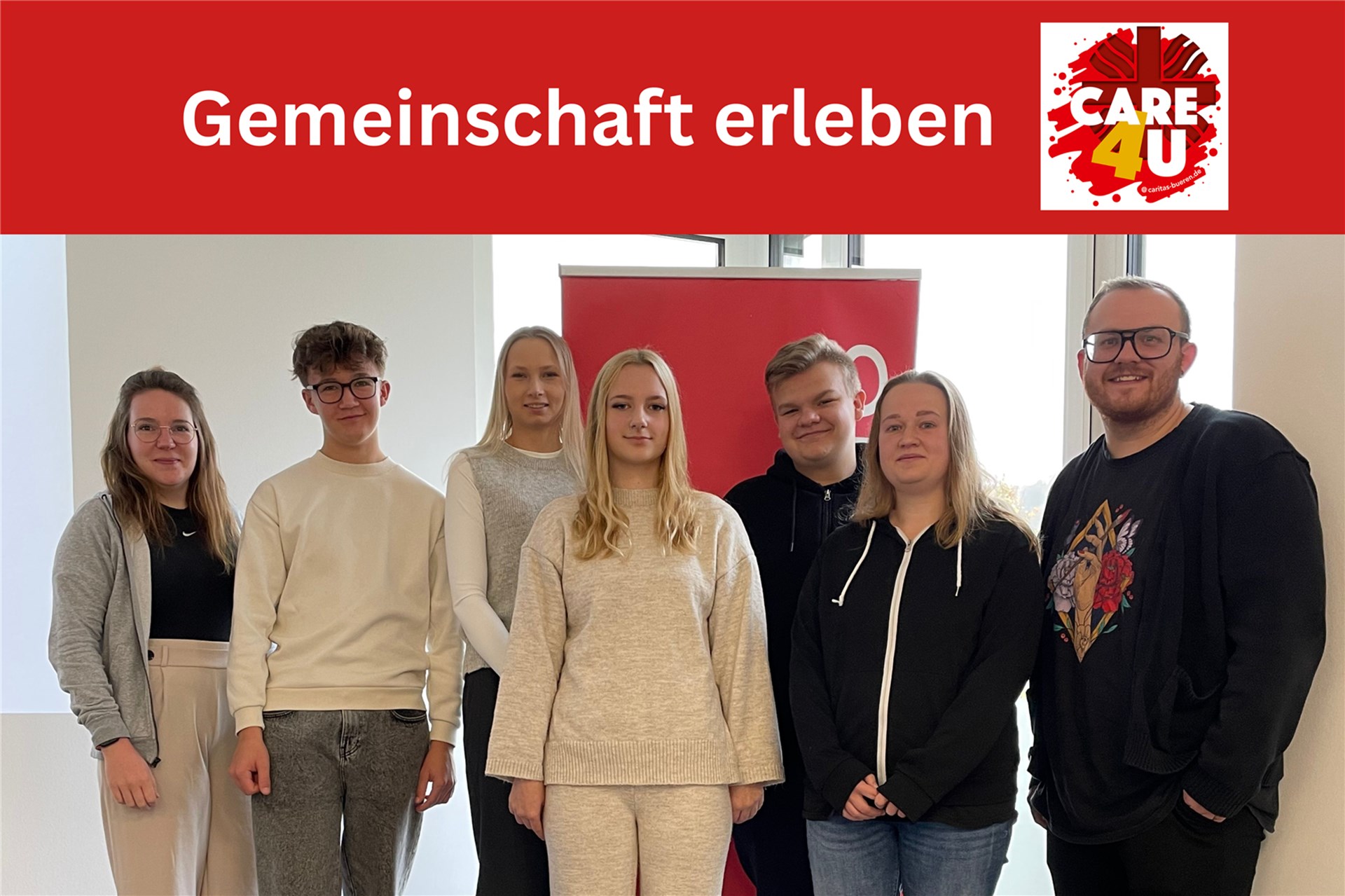 4 Frauen und 3 Männer stehen vor einer Glaswand. Allte tragen alltagstaugliche Kleidung 